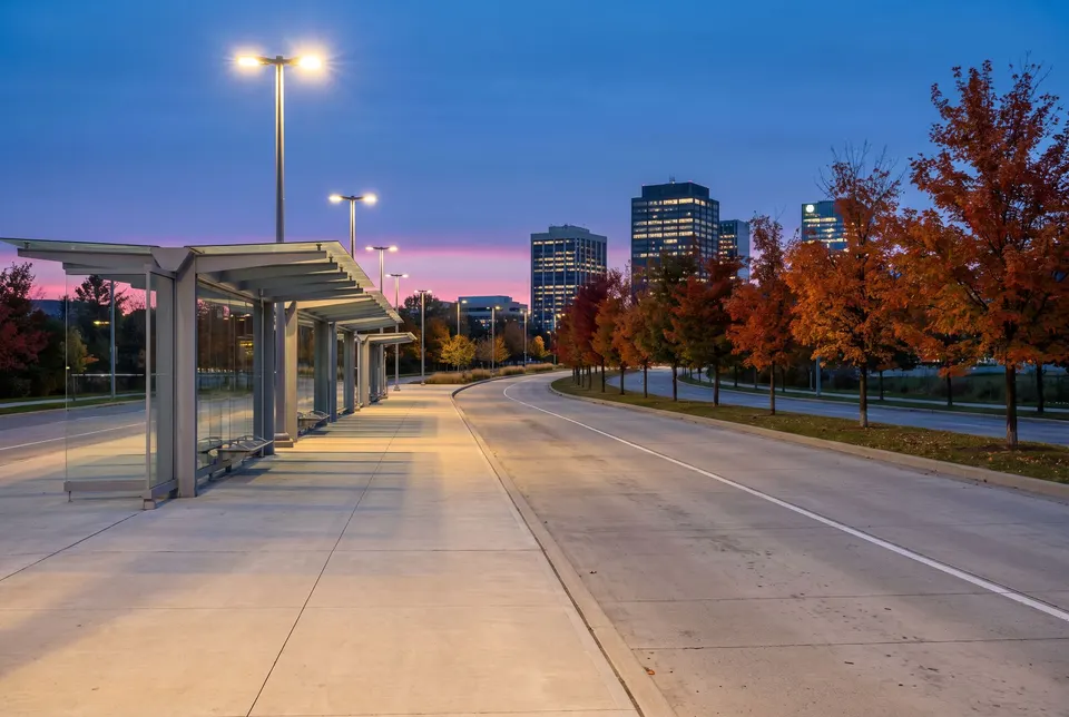 Station d’autobus vide au crépuscule, quai et abris de verre